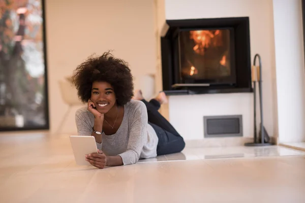 Чорна жінка використовує планшетний комп'ютер на підлозі — стокове фото