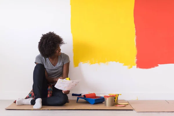 Negro pintor femenino sentado en el suelo — Foto de Stock