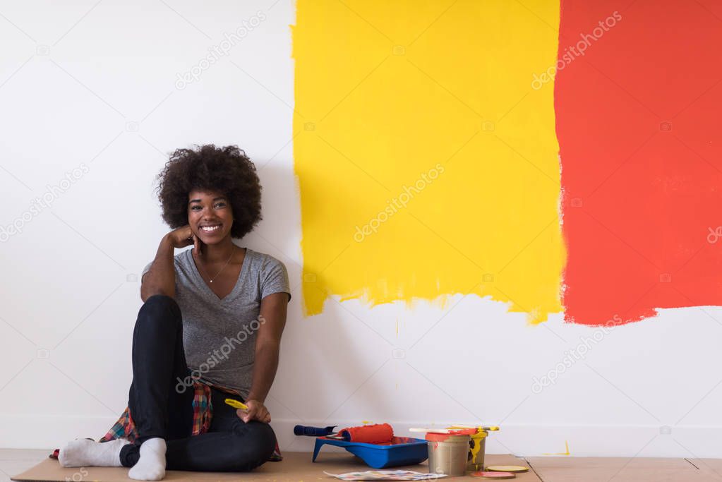 black female painter sitting on floor