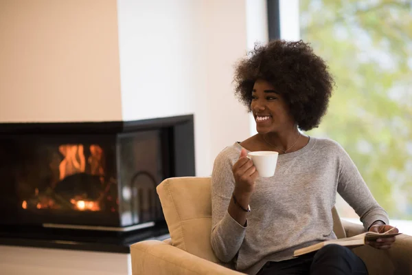 暖炉の前で本を読んで黒人女性 — ストック写真