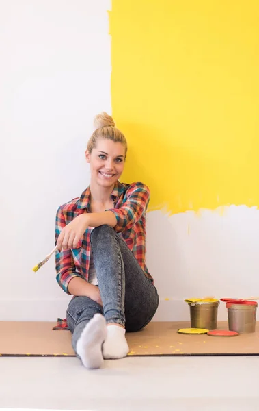 Ung kvindelig maler sidder på gulvet - Stock-foto