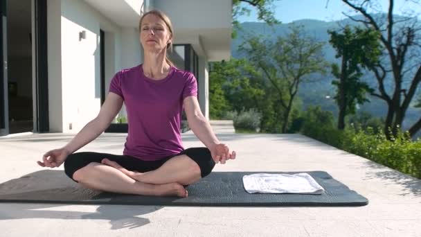 Mulher fazendo Yoga na frente da vila — Vídeo de Stock