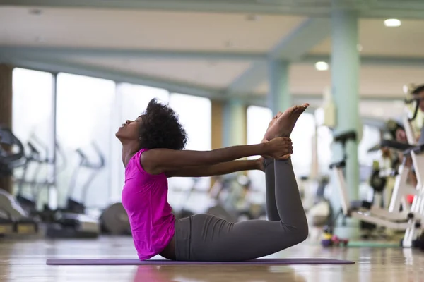 Mujer afroamericana ejercita yoga en gimnasio — Foto de Stock