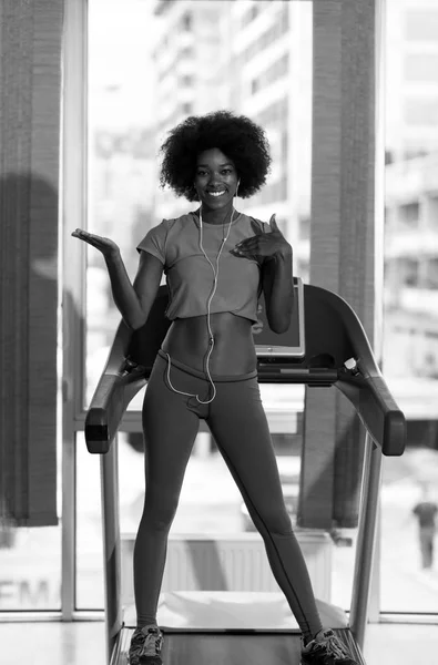 Afro américaine femme courir sur un tapis roulant — Photo