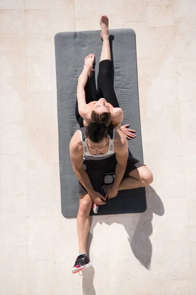 Vrouw met personal trainer ochtend yoga doen — Stockfoto