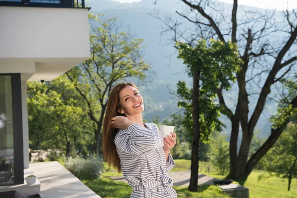 Žena v županu si vychutnat ranní kávu — Stock fotografie