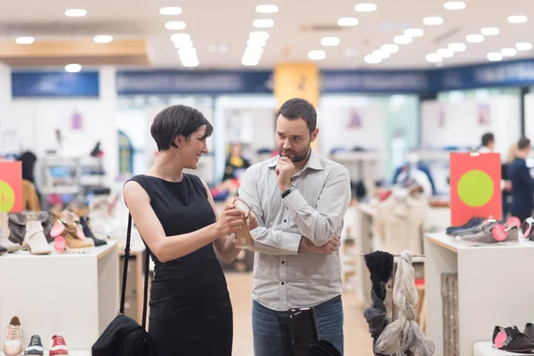 Pareja elige zapatos en tienda de zapatos — Foto de Stock