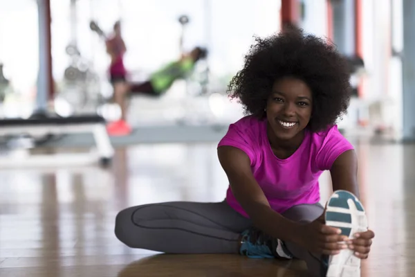 Kvinna i ett gym stretching och värmer upp — Stockfoto