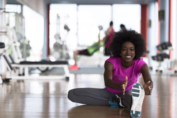 Frau im Fitnessstudio dehnt sich und wärmt sich auf — Stockfoto