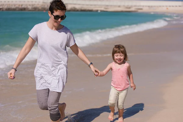 해변을 달리고 있는 엄마와 딸 — 스톡 사진
