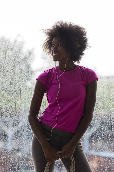 Porträtt av unga afro amerikansk kvinna i gymmet medan lyssnande mus — Stockfoto