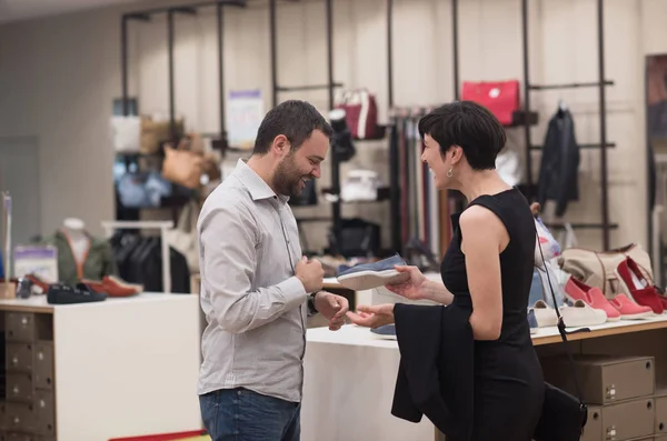 Paar kiest schoenen bij schoenenwinkel — Stockfoto