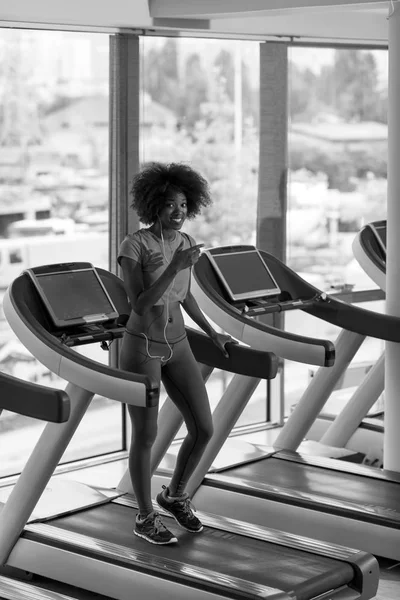 Mujer afroamericana corriendo en una cinta de correr — Foto de Stock