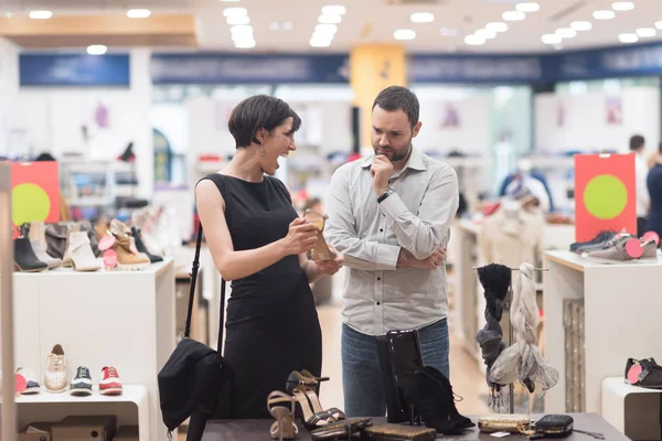 Pareja elige zapatos en tienda de zapatos — Foto de Stock