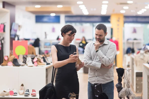 Pareja elige zapatos en tienda de zapatos —  Fotos de Stock