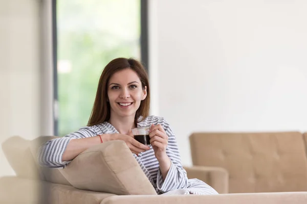 Mujer joven en un albornoz disfrutando del café de la mañana —  Fotos de Stock