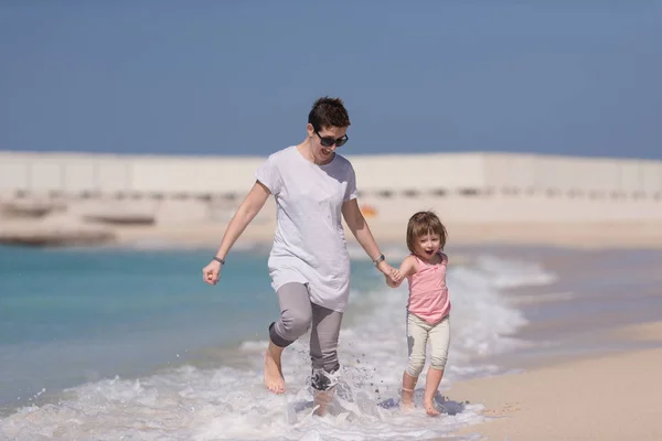 Anya és lánya fut a strandon — Stock Fotó