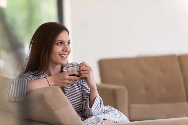 Ung kvinna i en morgonrock som du njuter av morgonkaffet — Stockfoto