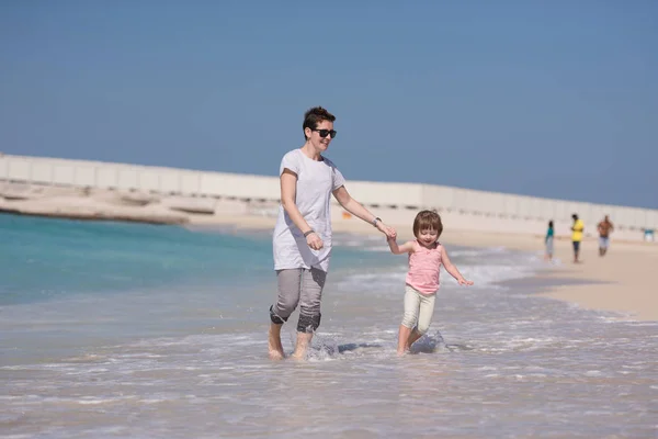 Mutter und Tochter rennen am Strand — Stockfoto