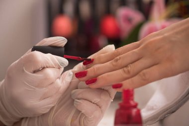 Kadın elleri manikür yaptırıyor.