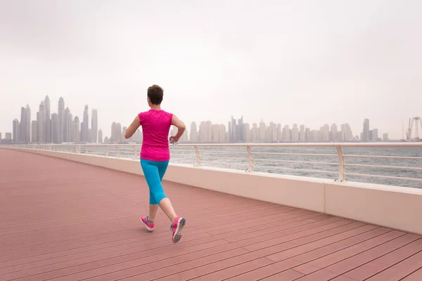 Mujer corriendo en el paseo marítimo — Foto de Stock