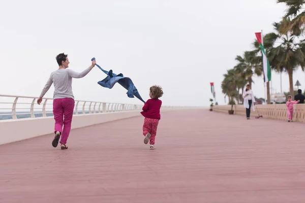Mother and cute little girl on the promenade by the sea — Stock Photo, Image