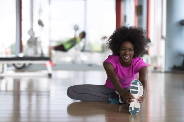 Frau im Fitnessstudio dehnt sich und wärmt sich auf — Stockfoto