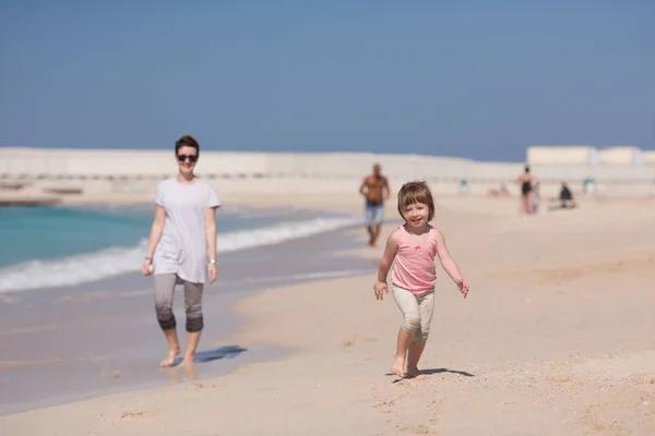 Mutter und Tochter rennen am Strand — Stockfoto