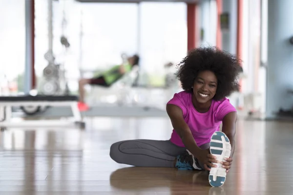 Frau im Fitnessstudio dehnt sich und wärmt sich auf — Stockfoto