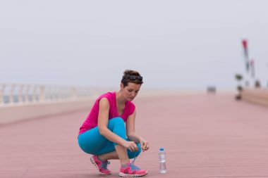 genç kadın üzerinde spor ayakkabı ayakkabı bağcığı bağlama