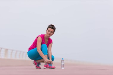 genç kadın üzerinde spor ayakkabı ayakkabı bağcığı bağlama