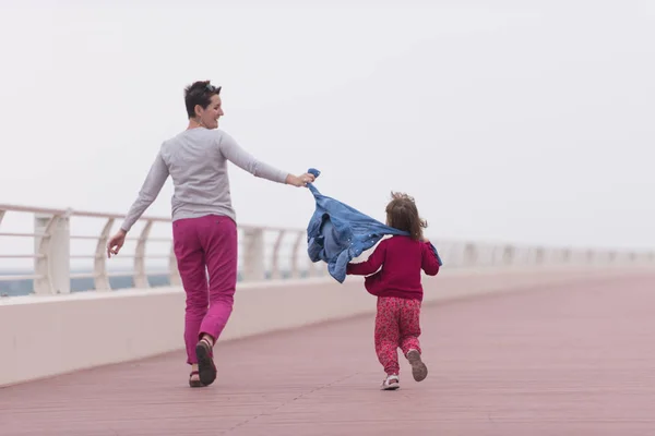 Mutter und süßes kleines Mädchen auf der Promenade am Meer — Stockfoto