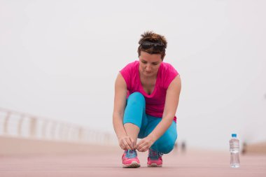 genç kadın üzerinde spor ayakkabı ayakkabı bağcığı bağlama