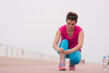 genç kadın üzerinde spor ayakkabı ayakkabı bağcığı bağlama