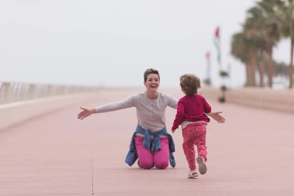 Mutter und süßes kleines Mädchen auf der Promenade am Meer — Stockfoto