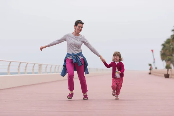 Mãe e linda menina no passeio à beira-mar — Fotografia de Stock