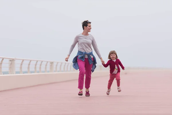 Η μητέρα και το χαριτωμένο μικρό κορίτσι στο χώρο περιπάτου δίπλα στη θάλασσα — Φωτογραφία Αρχείου