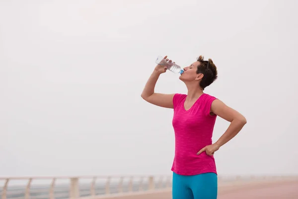 Фітнес жінка п'є воду — стокове фото