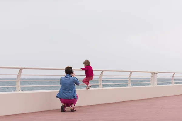 Мама и милая маленькая девочка на набережной у моря — стоковое фото