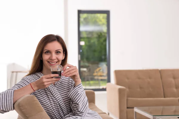 Ung kvinna i en morgonrock som du njuter av morgonkaffet — Stockfoto