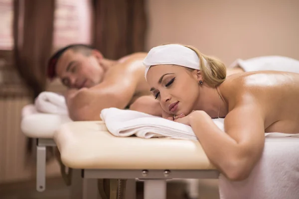 Giovane coppia sdraiata sul lettino da massaggio — Foto Stock