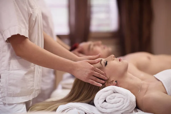 Casal desfrutando de massagem na cabeça no spa — Fotografia de Stock