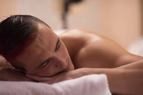 Schöner Mann, der sich in einem Wellness-Massagezentrum ausruht — Stockfoto