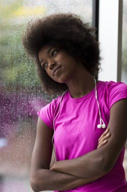 Pencerede Afro-Amerikalı genç bir kadın var.
