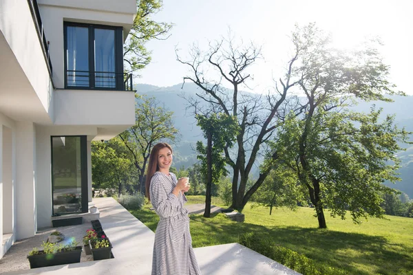 Vrouw in een badjas genieten van koffie in de ochtend — Stockfoto