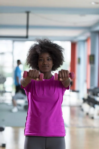 在与哑铃的运动量来找到健身房锻炼的女人 — 图库照片