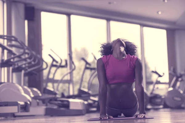 Mujer afroamericana ejercita yoga en gimnasio —  Fotos de Stock