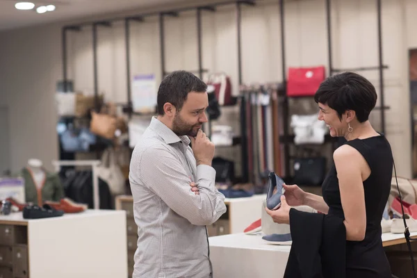 Pareja elige zapatos en tienda de zapatos —  Fotos de Stock