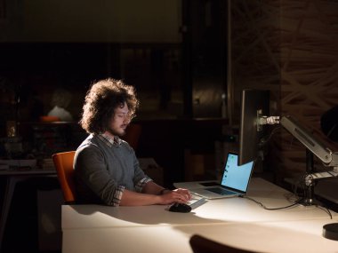 karanlık ofisinde bilgisayarda çalışan adam