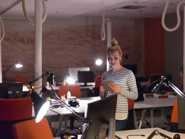 Femme travaillant sur tablette numérique dans le bureau de nuit — Photo